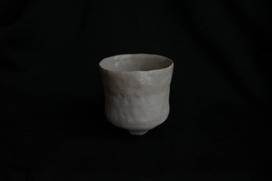 Handcrafted minimalist ceramic cup with natural texture on black background